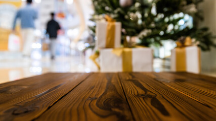 Wood table in front of Christmas tree and gift boxes