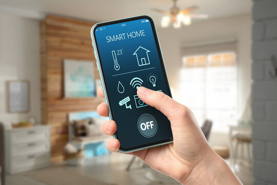 Woman using smart home app on mobile phone in room, closeup