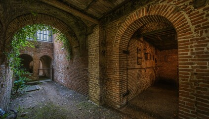 Obraz premium Ancient fortress featuring a red brick tunnel, elevated hallway, and a cellar housing a hidden pathway in Fort Number 5, dedicated to a historical monarch.