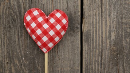 Obraz premium Heart-shaped red checkered decoration on a wooden stick