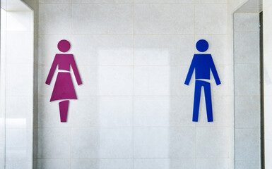 The gender signs for public restrooms are on the wall