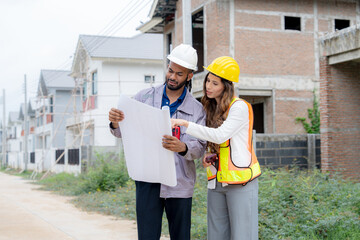 Construction workers with safety gear holding blueprints and discussing project design at residential building area teamwork, architecture, engineering, and housing development concept.
