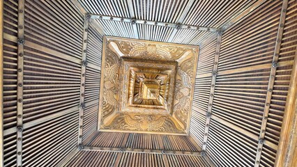 Intricate wooden ceiling patterns, creating a dizzying visual effect with geometric designs and radiating lines