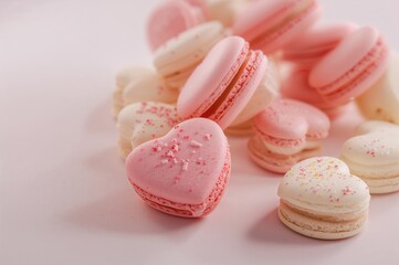 Fototapeta premium Sweet macarons in a heart shape set against a plain backdrop