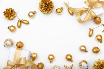 White Christmas background with golden gifts, baubles and pine cones. Stylish minimalist composition with copy space in the center.
