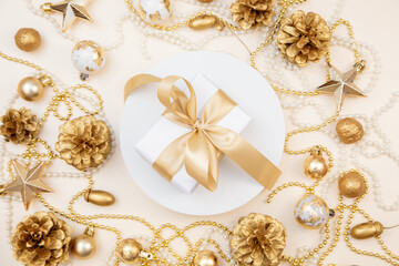 Golden Christmas and New Year frame with gifts, ornaments, pine cones, and pearls. Flat lay background with copy space for text or festive design.