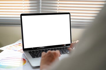 Person choosing color swatches on a desk with mock up laptop white screen at desk