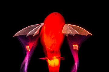 Long exposure of brightly lit objects floating in the night sky