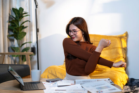 Young woman stretching during work from home break - Powered by Adobe