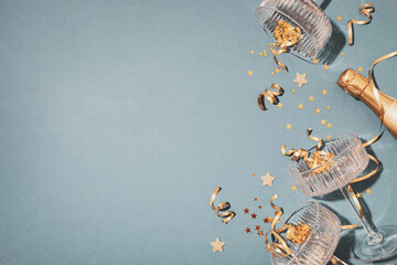 Party fashion background with champagne glasses and bottle and golden confetti stars. Christmas, birthday or wedding concept. Flat lay style. © juliasudnitskaya