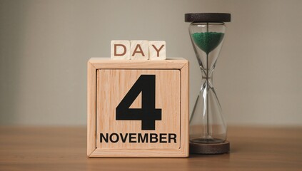 Handcrafted wooden block showing the date and a green sand hourglass symbolizing the passage of time in an autumn setting