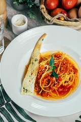 Delicious spaghetti with rich tomato sauce, served with a piece of garlic bread