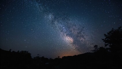 Milky Way ascending over a remote village, captured with long exposure causing noise and grain effects