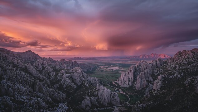 Fototapeta Approaching tempest looming above serene, rugged mountain landscape at dusk