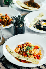 A selection of gourmet pasta dishes artfully arranged on elegant plates, showcasing a culinary delight