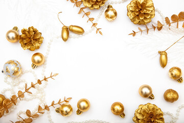 White Christmas composition with golden baubles, branches and pine cones. Minimal festive background with copy space.