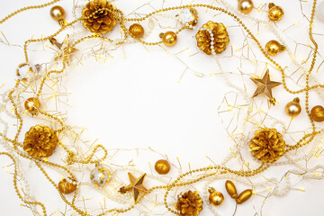 Christmas lights and gold baubles on white background. Copy space for festive greeting or design.