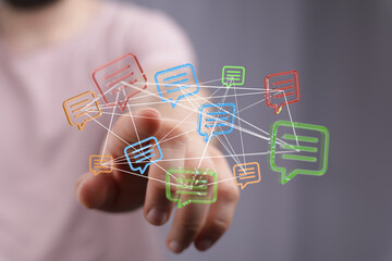 Hand touching digital message bubbles symbolizing connection, communication, social network, and global interaction. Modern technology concept.