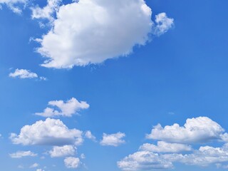 Bright Blue Sky with Fluffy White Cumulus Clouds in Clear Sunny Weather, Natural Beautiful Cloudscape Background Texture