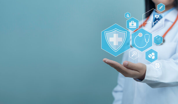 Female doctor in white coat with digital medical interface with health icons, stethoscope, pills and heartbeat symbol, representing health checkup, health insurance and modern healthcare system.
