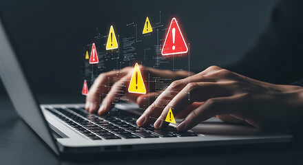 Hands typing on a laptop with digital warning alert icons displaying on the screen, signifying potential security threats or system errors.