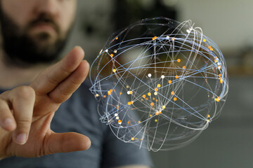 A man's hand interacting with a glowing global network connection sphere representing technology,...