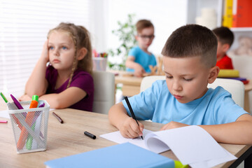 Children at wooden desks during art lesson in elementary school