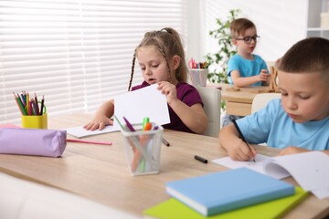 Fototapeta premium Children at wooden desks during art lesson in elementary school