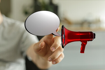 Concept image of a hand holding a red megaphone with a blank speech bubble. Perfect for...