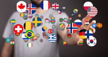 Fototapeta premium Person's hand reaching towards floating flags of various countries, symbolizing globalism, unity, and international connections. Represents trav