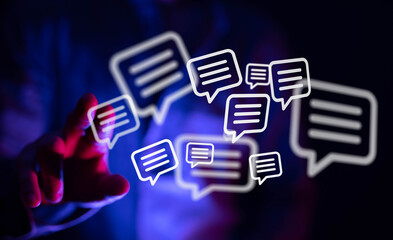 A hand touching glowing chat bubbles, representing online communication, interaction, and digital interface, symbolizing connection and networki