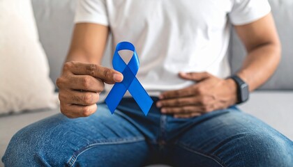 Obraz premium Man Holding Belly with Blue Awareness Ribbon – Prostate Cancer Awareness Concept
