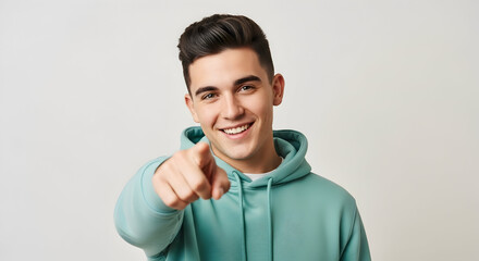 Smiling Student in Hoodie Reaching Out Portrait of a Confident Young Man Pointing at the Camera Happy Male Model Expressing Positivity Human Connection and Opportunity