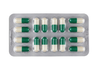 Green and white capsules in blister pack isolated, pharmaceutical medication for healthcare and treatment on a clean background