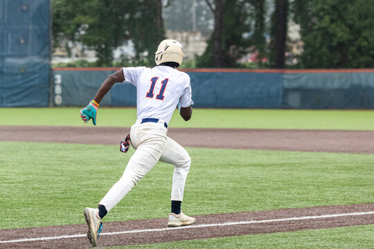 Baseball Player Running to First Base on a Turf Field