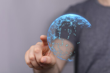 A person's finger interacts with a digital globe, symbolizing interconnectedness, technology, and...