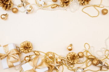 Golden Christmas and New Year frame with gifts, ornaments, pine cones, and pearls. Flat lay background with copy space for text or festive design.