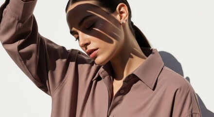 Woman in oversized shirt with shadows on her face and wall