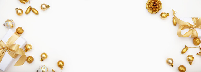 White Christmas background with golden gifts, baubles and pine cones. Stylish minimalist composition with copy space in the center.