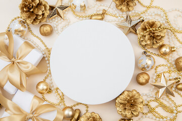 Round white board with golden Christmas and New Year decorations, pine cones, and gift boxes. Flat lay with copy space for text or logo.