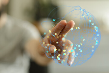 Hand reaching out to touch a network sphere representing global connections and technology, concept.