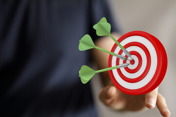 Achieving the target goal, hitting the bullseye, with three darts on a dartboard. Concept of...