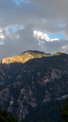 Dramatic sunlight hitting mountain peak showing power and contrast in nature