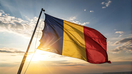 Romanian flag waving in the wind against a bright sunset sky