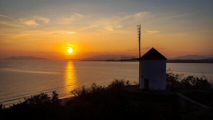 A stunning sunset over the Andaman Sea at Windmill View Point, located near Laem Promthep Cape in Phuket, Thailand