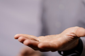 Obraz premium A close-up shot of a person's open hand, palm up, offering or receiving. The background is blurred, creating space for copy. Great for concepts
