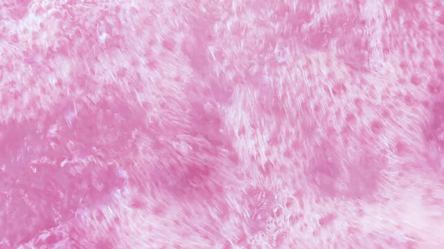 Pink bubbling liquid boiling texture. Carbonated drink background.