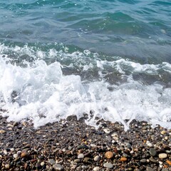 Gentle sea waves washing over pebbles on shore showing natural movement and calmness
