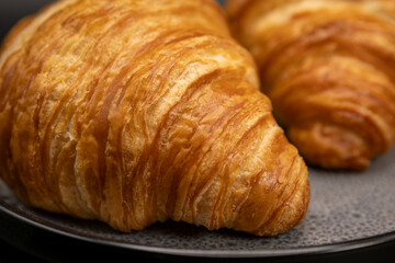 Golden Butter Croissant Close-Up – Crisp Layers and Buttery Flake Texture on Dark Plate