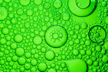 Close-up green macro bubble texture,Macro microscope green bubble texture, Close-up Green bubbles and drops oil background . golden green water bubbles, close up golden oil drop for cosmetic